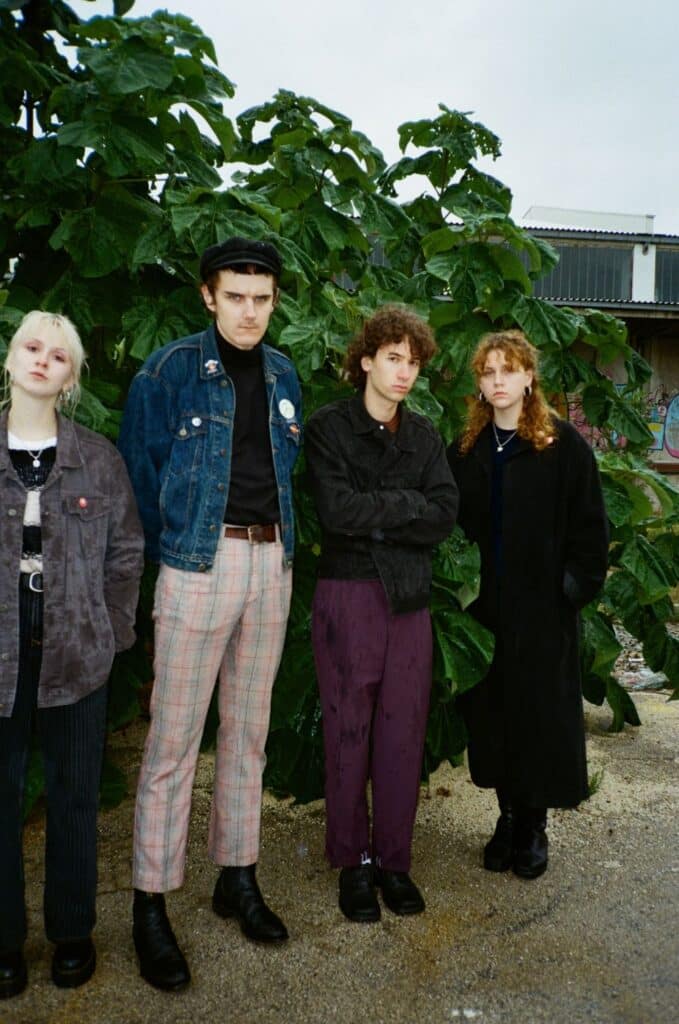 Gruppenbild der Band LAUNDROMAT CHICKS in einem Hof vor einem Baum