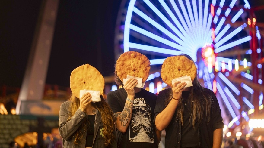 Bandfoto der Wiener Band Speck, Mitglieder halten Langos vor ihren Geichtern